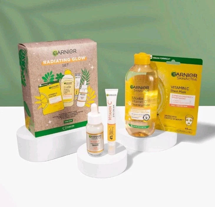 Garnier Radiating Glow skincare set with Vitamin C micellar cleansing water, serum, and sheet mask.