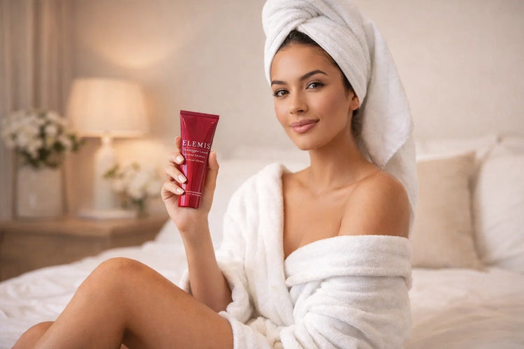 Best Seller skincare tube held by a woman in a white bathrobe with a towel wrap in a cozy bedroom.
